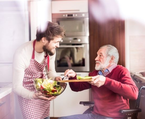 Personne en chaise roulante dans sa cuisine.